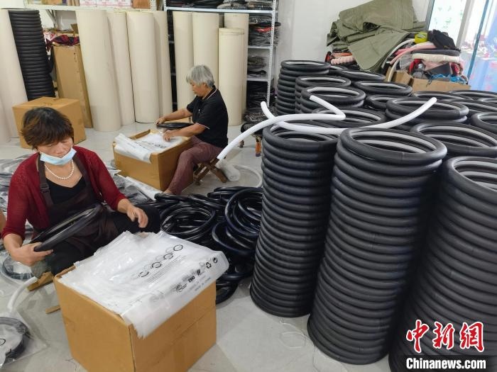 圖為村民在汽車飾品企業(yè)生產(chǎn)車間中工作?！巫雍?攝