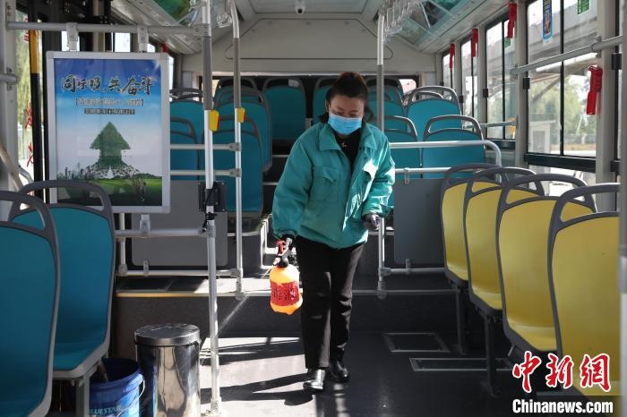 工作人員正在對公交車進(jìn)行消殺?！∮诰?攝