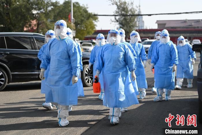 圖為醫(yī)務人員在封閉小區(qū)做防控工作?！⑽娜A 攝