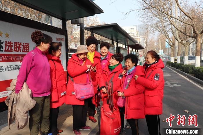 “防詐奶奶團”在等公交車的間隙也不忘探討工作 李明芮 攝