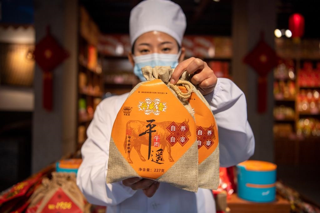 1月27日，在平遙古城南大街的一家平遙牛肉店內(nèi)，工作人員展示一款牛肉產(chǎn)品。新華社記者 楊晨光 攝