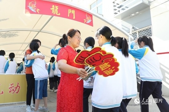 6月7日一早，雄安新區(qū)安新中學(xué)老師在給同學(xué)們加油鼓勁兒。人民網(wǎng) 李兆民攝