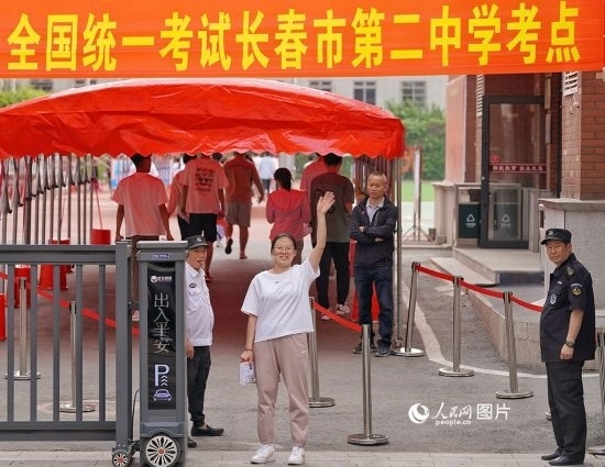 6月7日，在長(zhǎng)春市第二中學(xué)考點(diǎn)，一名考生信心滿滿進(jìn)入考場(chǎng)，并與家長(zhǎng)揮手致意。人民網(wǎng)記者 李洋攝