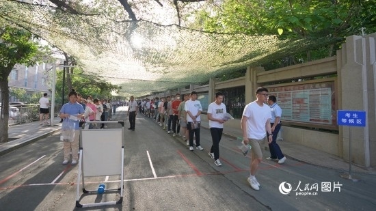 6月7日，烏魯木齊市第七十中學(xué)門口，考生們有序進(jìn)入考場(chǎng)。人民網(wǎng) 李欣洋攝