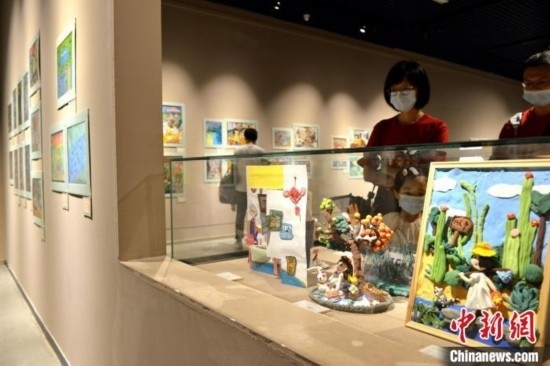 圖為家長帶著孩子參觀展覽。呂明 攝