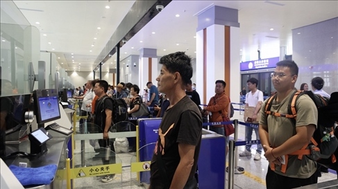 6月13日，乘坐中老鐵路國際旅客列車的旅客在磨憨邊檢大廳排隊候檢。李揚 攝