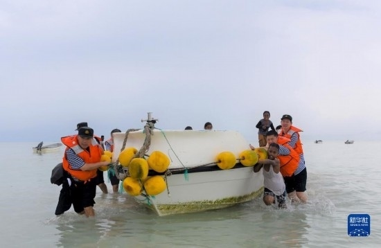 7月21日，中國(guó)海軍“和平方舟”號(hào)醫(yī)院船醫(yī)護(hù)人員涉水登島，前往基里巴斯一診療點(diǎn)。新華社記者 黎云 攝