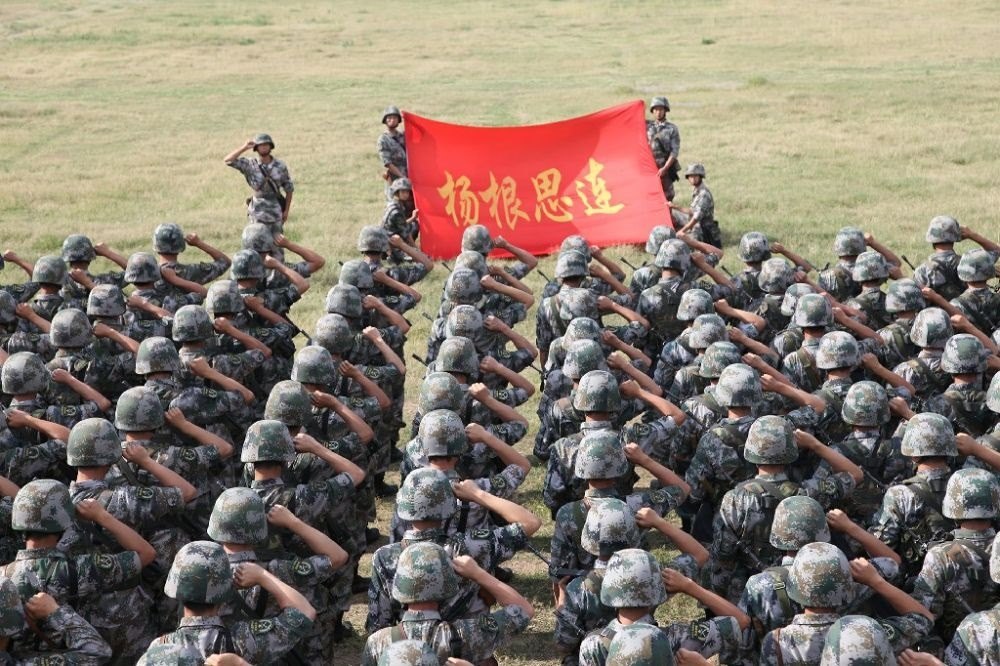 ↑“楊根思連”官兵執(zhí)行任務(wù)前向連旗宣誓（資料照片）。新華社發(fā)