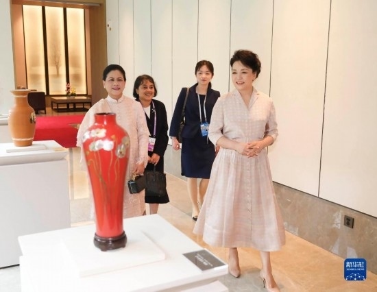 7月27日下午，國家主席習(xí)近平夫人彭麗媛在四川成都會(huì)見陪同印度尼西亞總統(tǒng)佐科來華出席第31屆世界大學(xué)生夏季運(yùn)動(dòng)會(huì)開幕式并訪華的總統(tǒng)夫人伊莉亞娜。這是彭麗媛和伊莉亞娜欣賞成都特色非遺工藝品。新華社記者 丁林 攝