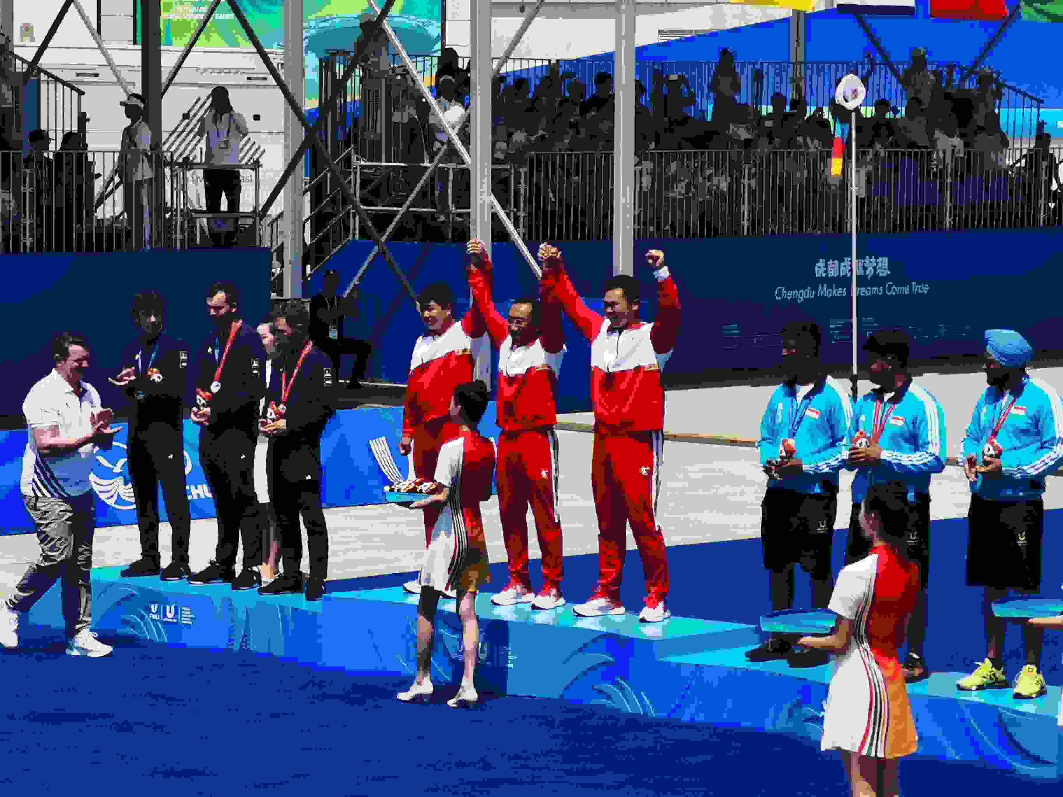 7月30日，在成都大運會男子復合弓團體頒獎儀式中，中國隊慶祝奪得冠軍。 人民網(wǎng)記者 楊磊攝