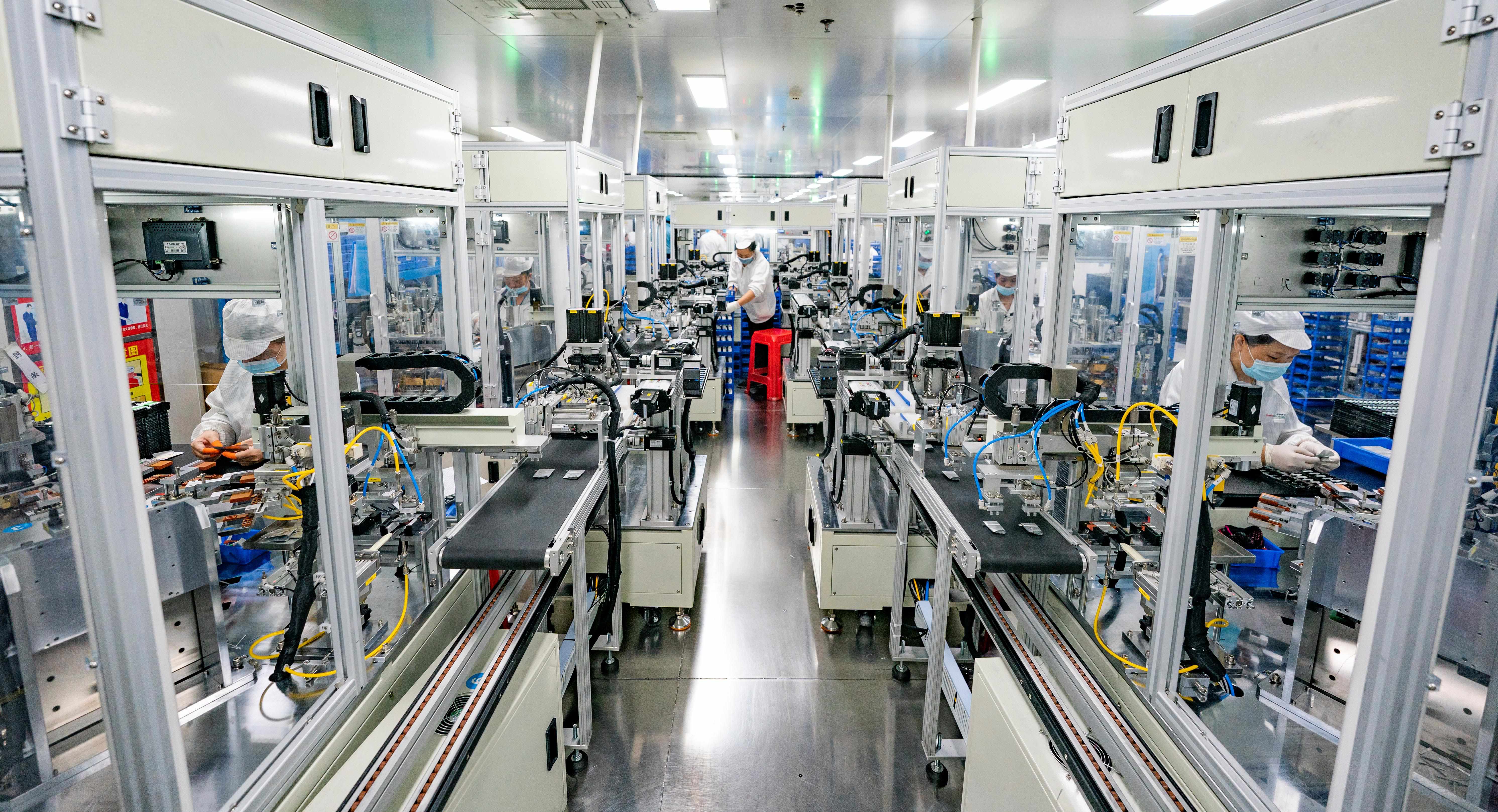 2023年5月17日，江西新余一家電子公司生產(chǎn)車間內，技術工人在鋰電池生產(chǎn)線忙于趕制訂單產(chǎn)品。