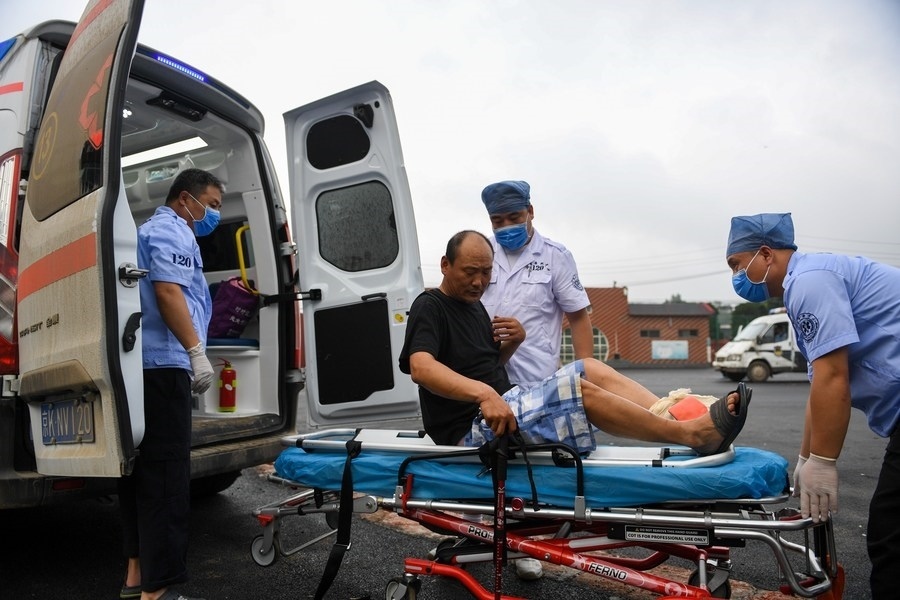 8月1日，在北京市門頭溝區(qū)妙峰山鎮(zhèn)妙峰山民族學(xué)校臨時(shí)安置點(diǎn)，北京急救中心工作人員在轉(zhuǎn)運(yùn)一名受傷村民。新華社記者 鞠煥宗 攝