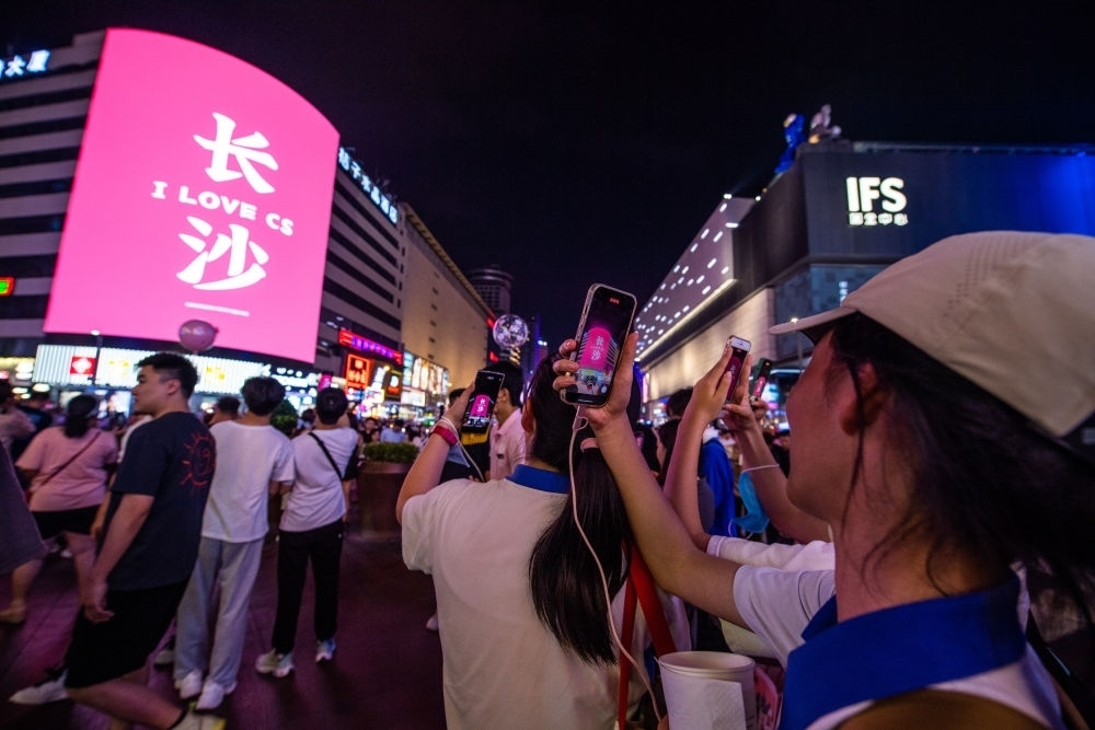  游客在長(zhǎng)沙市天心區(qū)黃興路步行街打卡、拍照（6月7日攝）。新華社記者 陳思汗 攝