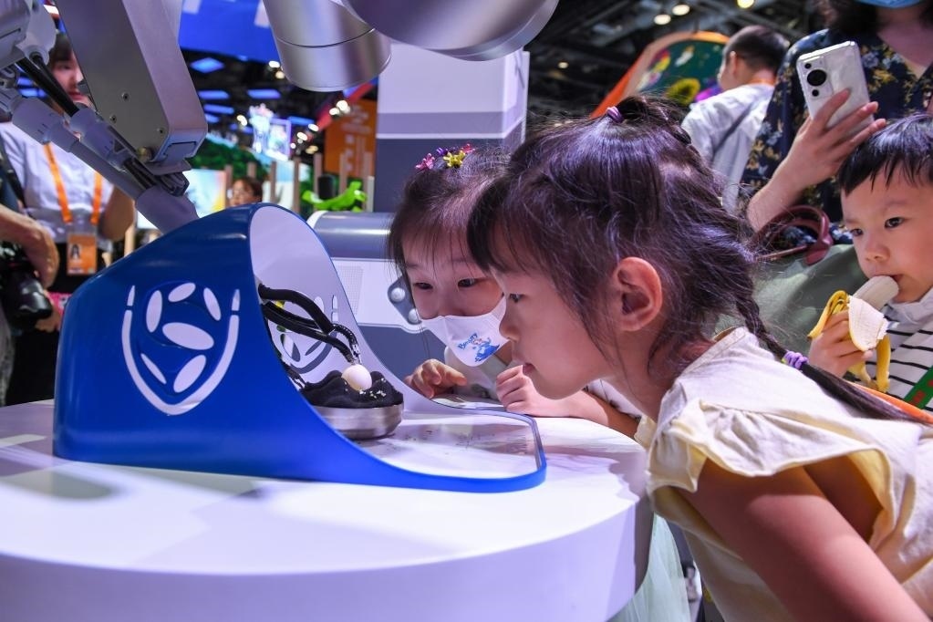 9月3日，幾名小朋友在國家會議中心觀看單孔腔鏡手術(shù)機(jī)器人展示。新華社記者 鞠煥宗 攝