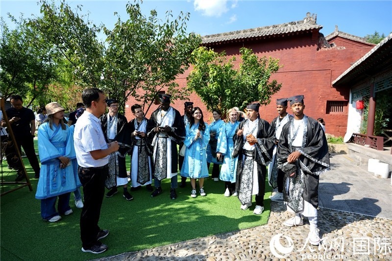 圖為選手們聽導(dǎo)游講解。人民網(wǎng) 盧鵬宇攝