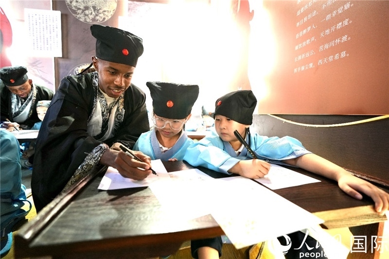 圖為選手與同學(xué)們一起寫書法。人民網(wǎng) 盧鵬宇攝