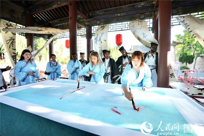 選手們提筆書寫“家園”二字。人民網(wǎng) 盧鵬宇攝