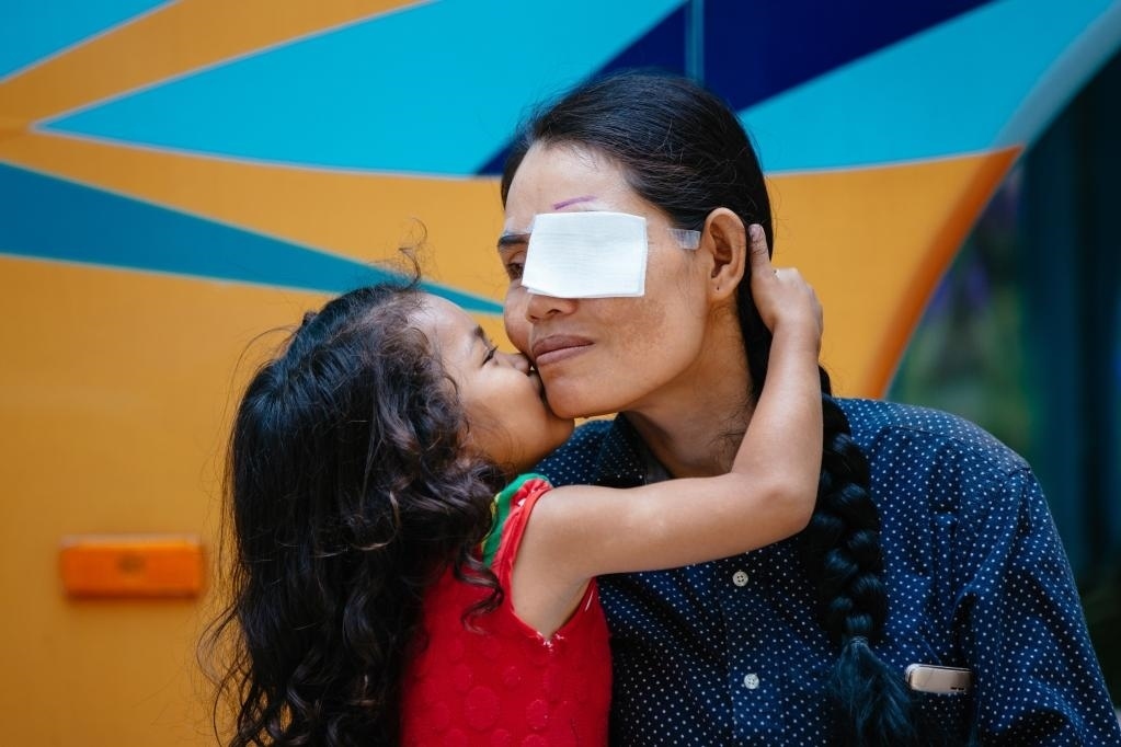 2019年3月15日，在柬埔寨磅湛省醫(yī)院，即將接受白內(nèi)障手術(shù)的患者孫美樂接受女兒的親吻祝福。在接受了中國(guó)醫(yī)療隊(duì)的白內(nèi)障義診手術(shù)后，她的視力逐步恢復(fù)，生活有了新的光明和希望。