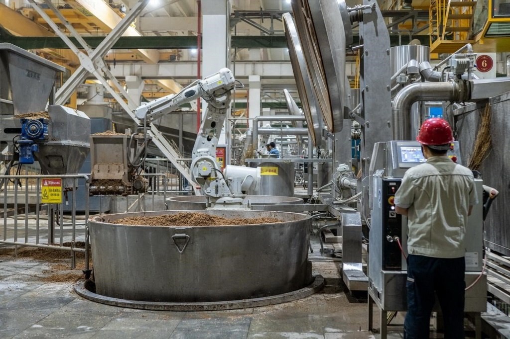 907車(chē)間里，機(jī)械臂正在撒料裝甑。嚴(yán)磊攝