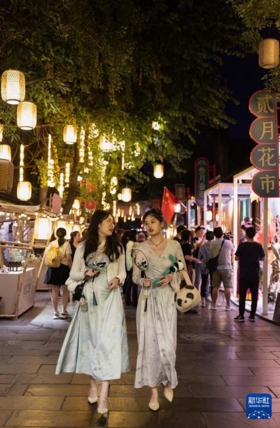 在成都寬窄巷子，兩位來(lái)自安徽的游客在新“十二月市”街區(qū)游覽（9月29日攝）。