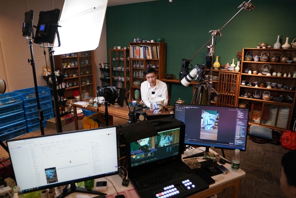 ↑在景德鎮(zhèn)，工作人員通過(guò)網(wǎng)絡(luò)直播推介陶瓷產(chǎn)品（2023年2月22日攝）。