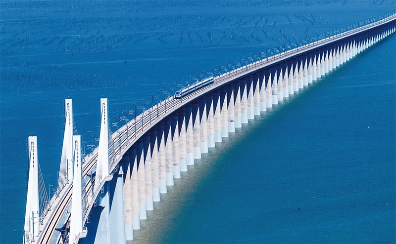 2023年9月28日，中國首條時速350公里跨海高鐵——福廈高鐵正式開通運營。圖為一列運行試驗車組駛過福廈高鐵湄洲灣跨海大橋（9月19日攝，無人機照片）。 新華社記者 魏培全/攝