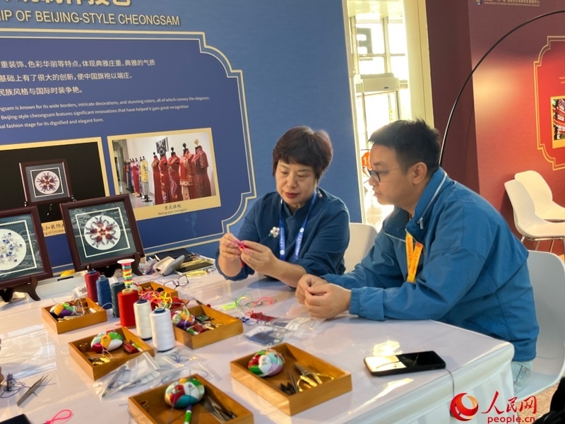 記者在新聞中心非遺傳承人展區(qū)進(jìn)行體驗(yàn)。人民網(wǎng)記者 杜燕飛攝