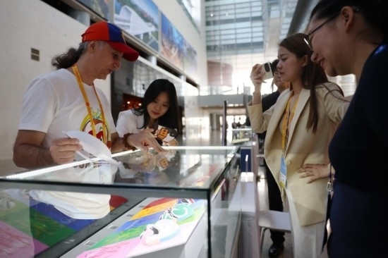 10月16日，參會(huì)記者在“一帶一路”國際合作高峰論壇新聞中心參觀展示的中國非物質(zhì)文化遺產(chǎn)展品。新華社記者 陳斌 攝