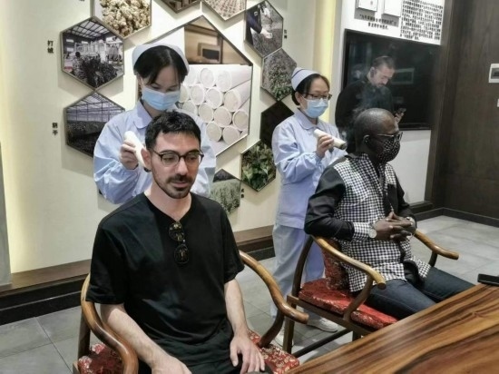 2023“一帶一路”媒體合作論壇聯(lián)合采訪團(tuán)團(tuán)員在九牛草展示館體驗(yàn)艾灸。（本報(bào)記者 黃超攝）