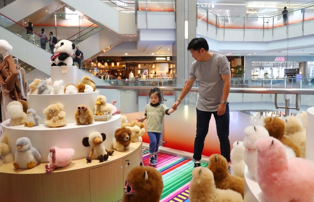 2023年11月2日，顧客在溫暖駝品牌專柜內(nèi)選購。連續(xù)六年參加進(jìn)博會的秘魯羊駝制品品牌溫暖駝在上海市中心商場開設(shè)了專柜。新華社記者 方喆 攝