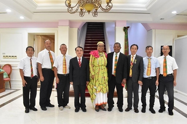 多米尼克總統(tǒng)伯頓和駐多米尼克大使林先江與中國(guó)農(nóng)業(yè)技術(shù)專家組合影。中國(guó)駐多米尼克大使館供圖