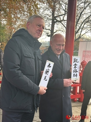 柏林市長韋格納（右）、動物園監(jiān)事會主席布魯克曼（左）手持中國文化中心工作人員現(xiàn)場手書的中文名字。人民網(wǎng)記者 徐馨攝