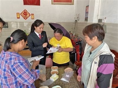  圖⑤：龍圩區(qū)法院法官到群眾家中開展法治宣傳。資料圖片