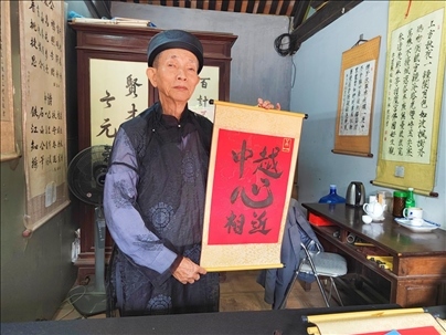 越南首都河內(nèi)文廟內(nèi)，阮明珠展示“中越心相近”書法作品。