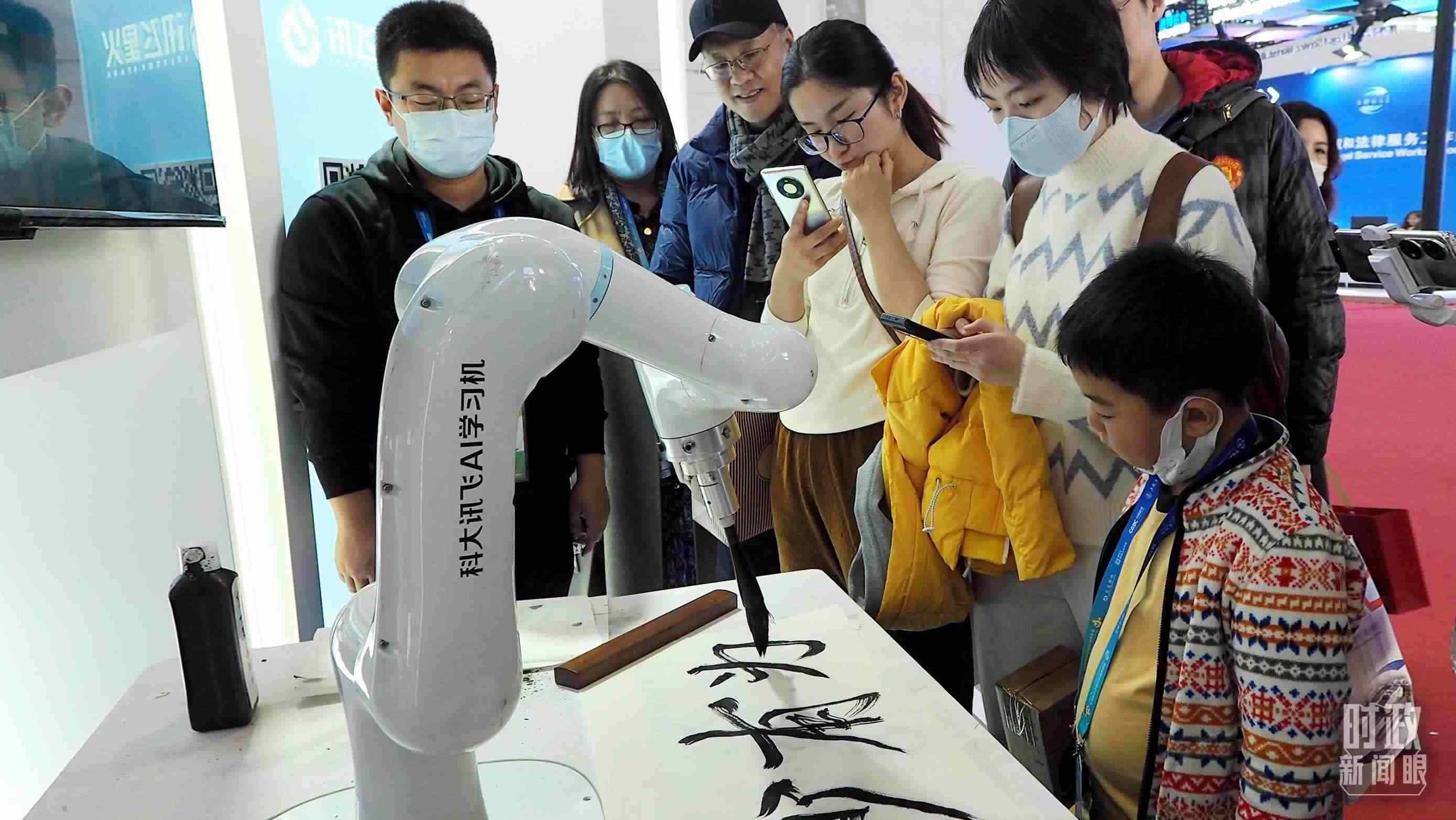 △觀眾在首屆鏈博會(huì)上體驗(yàn)AI書法機(jī)器人。
