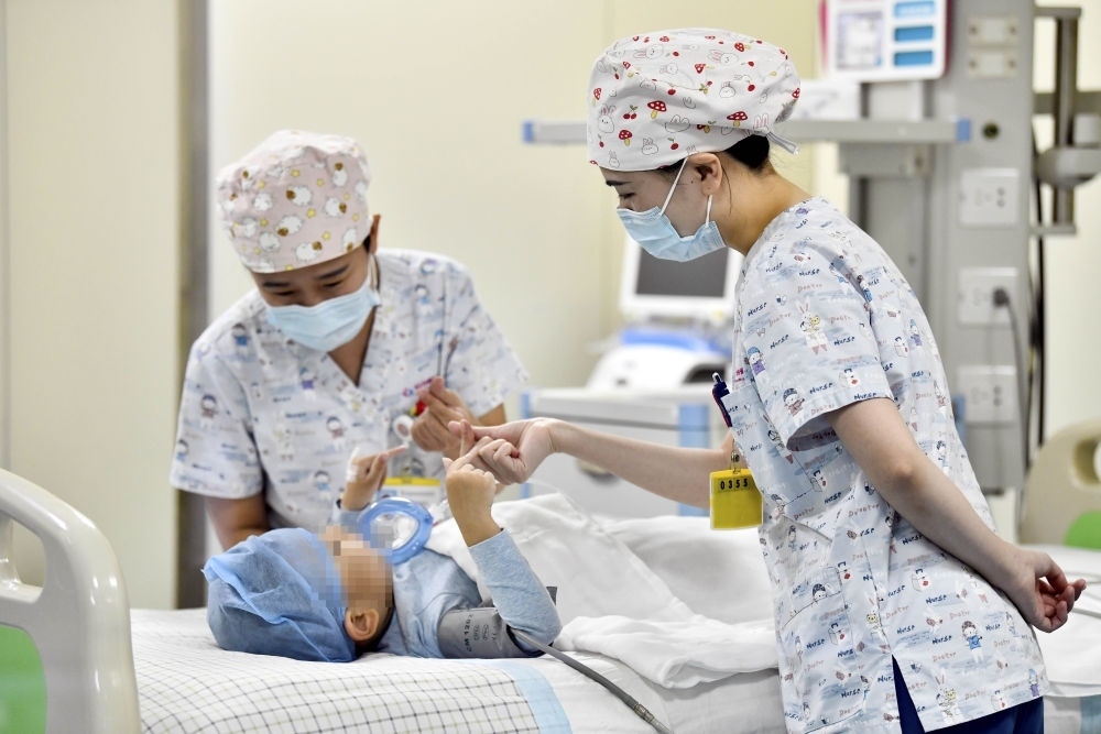 在山東省棗莊市婦幼保健院兒童ICU病房，醫(yī)護(hù)人員為完成靶向治療藥物諾西那生鈉的4歲脊髓性肌萎縮癥患兒加油鼓勁（2022年1月1日攝）。諾西那生鈉注射液是我國首個(gè)獲批治療脊髓性肌萎縮癥的進(jìn)口藥物，2019年進(jìn)入中國市場時(shí)，每針價(jià)格近70萬元。在2021年國家醫(yī)保目錄藥品談判中，以3.3萬元每針的價(jià)格進(jìn)入新版醫(yī)保藥品目錄。新華社記者 郭緒雷 攝