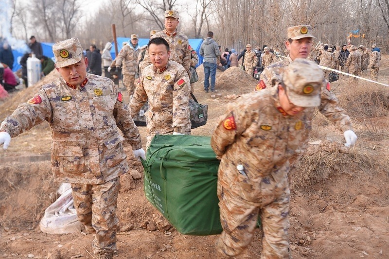 救援人員正在現場緊急搬運物資。賀勇攝。
