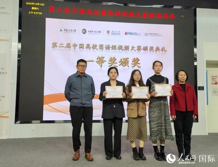 澳門大學(xué)中葡雙語教學(xué)暨培訓(xùn)中心主任姚京明（左一）和中國傳媒大學(xué)外國語言文化學(xué)院院長文春英（右一）為一等獎(jiǎng)獲得者頒獎(jiǎng)。人民網(wǎng)記者 魯揚(yáng)攝