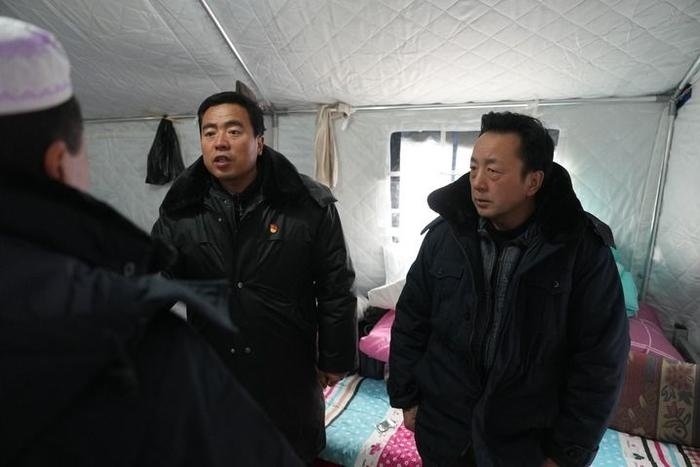 2023年12月22日，積石山縣大河家鎮(zhèn)大河村黨支部書記馬成忠（右二）在帳篷里和受災(zāi)群眾交流。新華社記者 陳斌 攝