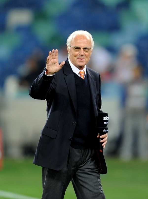 這是2010年7月7日，在南非德班舉行的2010年足球世界杯德國隊(duì)對陣西班牙隊(duì)的半決賽前，貝肯鮑爾接受電視臺采訪時(shí)和友人打招呼。新華社記者 王毓國 攝