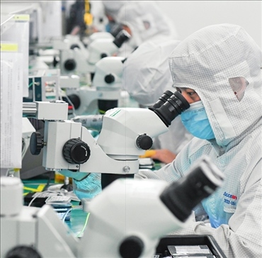 在位于武漢中國光谷的光電器件研發(fā)制造商——武漢光迅科技股份有限公司生產(chǎn)車間內(nèi)，技術(shù)人員在光模塊生產(chǎn)線作業(yè)（2023年4月11日攝）。程敏攝/本刊