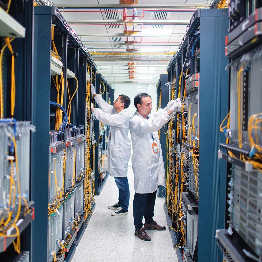 在位于武漢中國光谷的光電器件研發(fā)制造商——武漢光迅科技股份有限公司生產(chǎn)車間內(nèi)，技術(shù)人員在光模塊生產(chǎn)線作業(yè)（2023年4月11日攝）。程敏攝/本刊