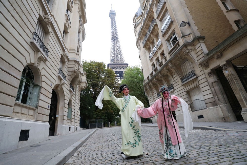 2023年9月13日，江蘇省演藝集團昆劇院院長施夏明（左）和江蘇省演藝集團昆劇院國家一級演員孔愛萍在法國巴黎埃菲爾鐵塔附近參加昆曲快閃。新華社記者 高靜 攝