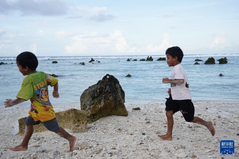 1月20日，兒童在瑙魯海邊嬉戲。新華社記者 王申 攝