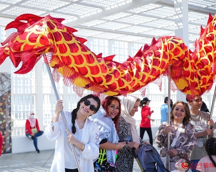 游客體驗(yàn)舞龍。 人民網(wǎng) 塔里克·易卜拉欣攝