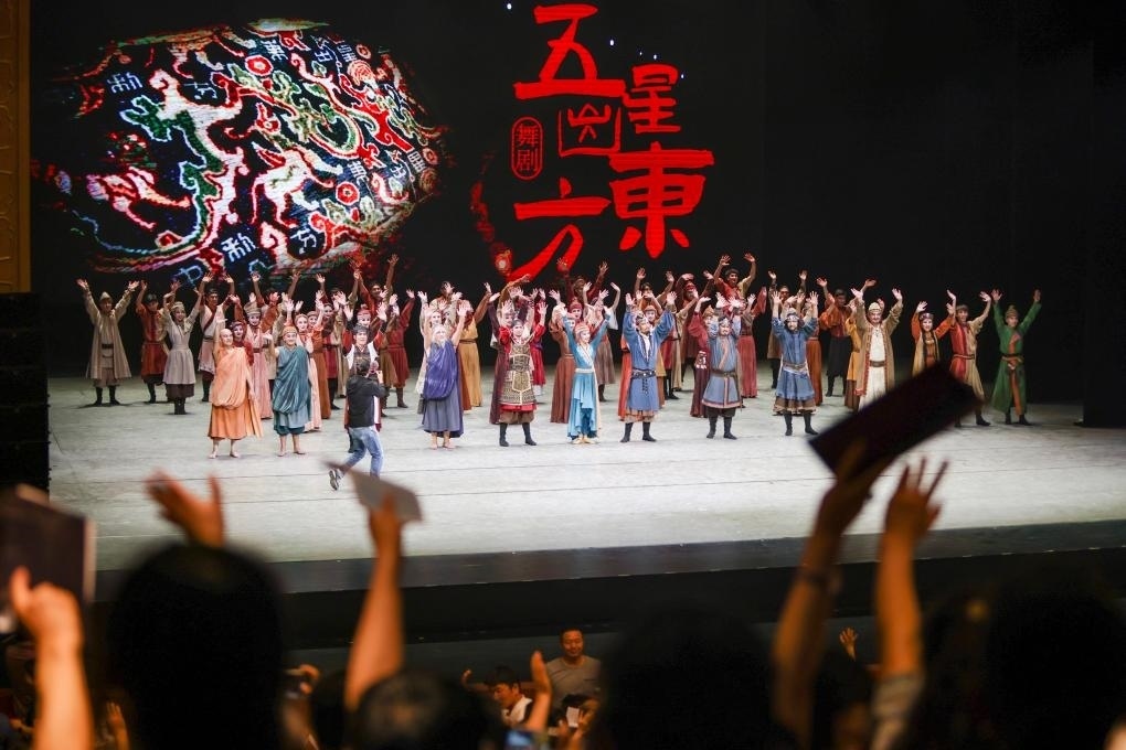 2023年7月31日，新疆和田地區(qū)新玉歌舞團(tuán)在烏魯木齊京劇院演出舞劇《五星出東方》后和觀眾互相揮手致意。這場(chǎng)演出是第六屆中國(guó)新疆國(guó)際民族舞蹈節(jié)的參演劇目之一，曾榮獲國(guó)家“文華獎(jiǎng)”等。新華社記者 郝昭 攝