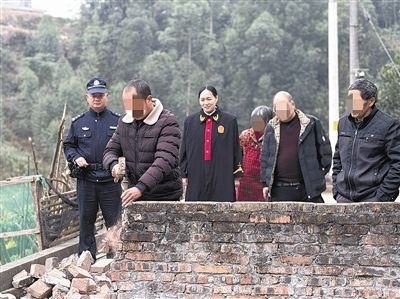  圖③：庭審結(jié)束后，在法官的見(jiàn)證下，陳某在院壩邊重新開(kāi)鑿一條通道。