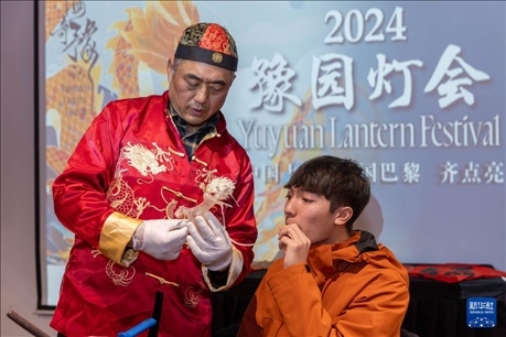 1月28日，在上海豫園舉行的民俗活動(dòng)上，美國馬斯卡廷中學(xué)學(xué)生在非遺傳承人的指導(dǎo)下吹糖偶。 新華社記者 王翔 攝