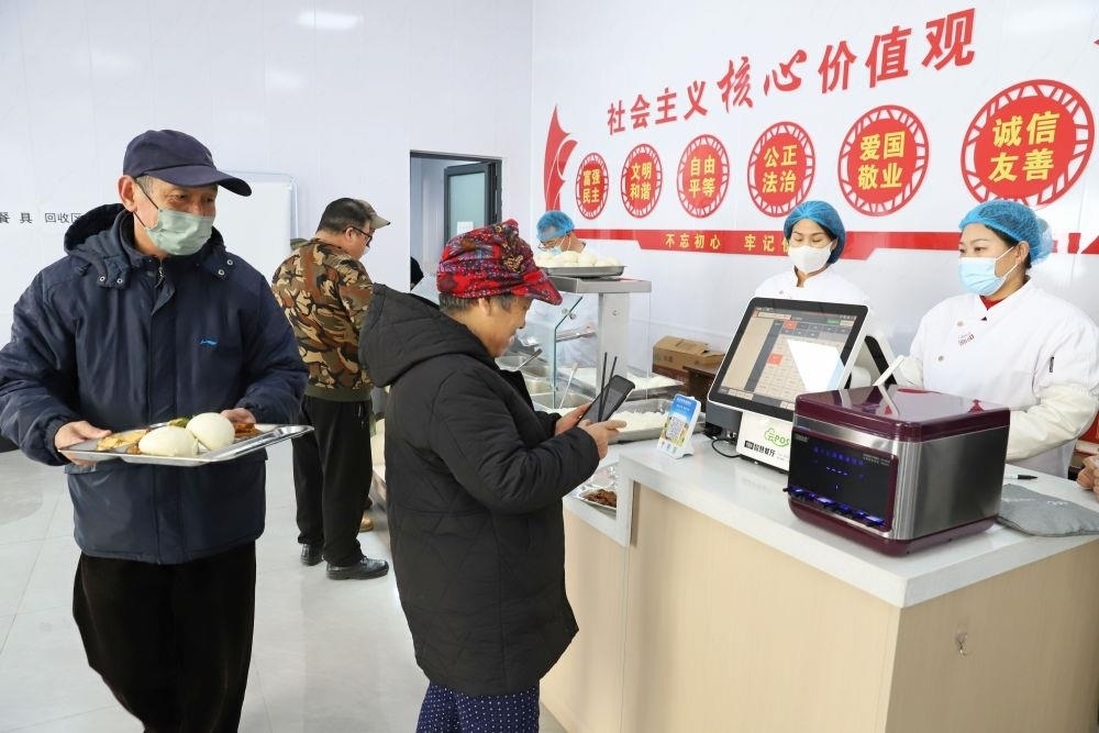 △2024年2月1日，市民在河北涿州市雙塔街道永濟秀園小區(qū)便民食堂內(nèi)購買午餐。