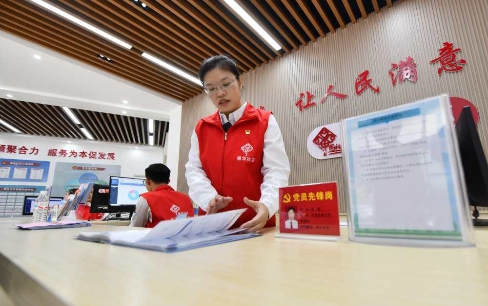 △2023年12月14日，廣西南寧市蟠龍社區(qū)，工作人員在為居民服務(wù)。